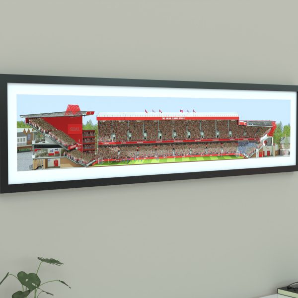 A panoramic cross-sectional illustration of the City Ground during a daytime Premier League match, filled with Nottingham Forest fans cheering.